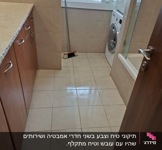 חדר כביסה עם מכונת כביסה ומטאטא